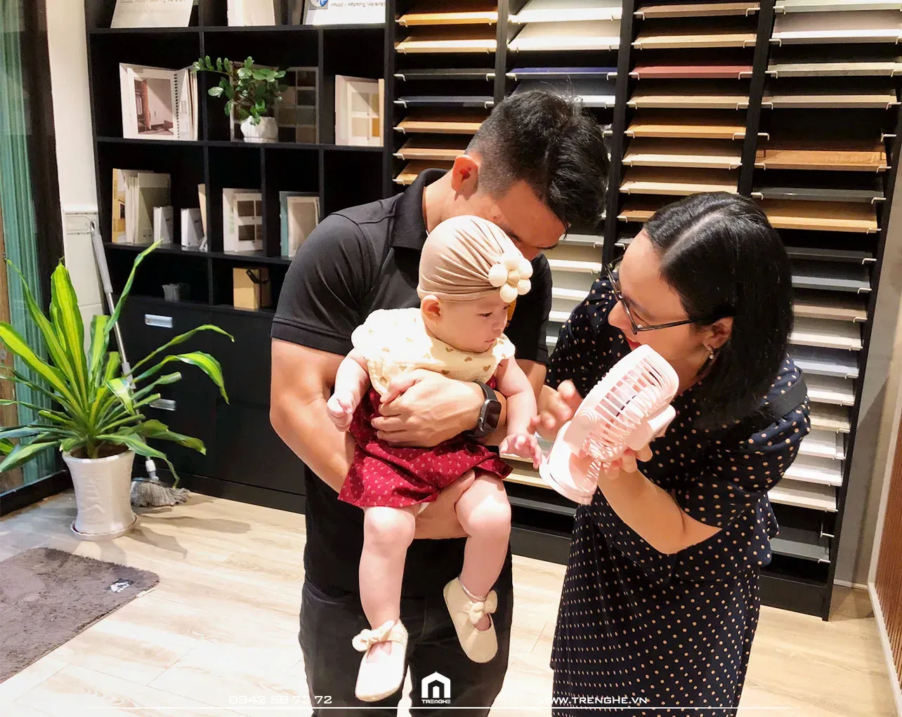 Em bé chăm chú khám phá đồ chơi mới cùng ba mẹ