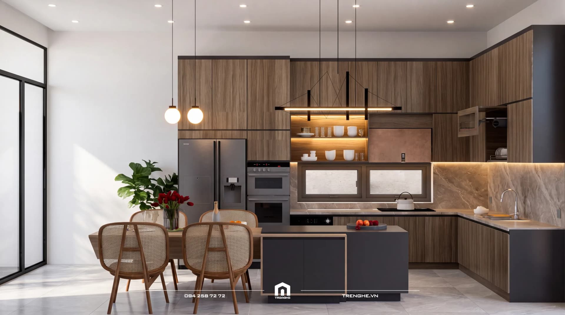 Gian bếp chữ L B’ Villa nhìn chính diện: tủ bếp vân gỗ trên dưới, đảo bếp xám, bàn ăn ghế mây, tủ lạnh hai cánh và lò nướng âm tủ