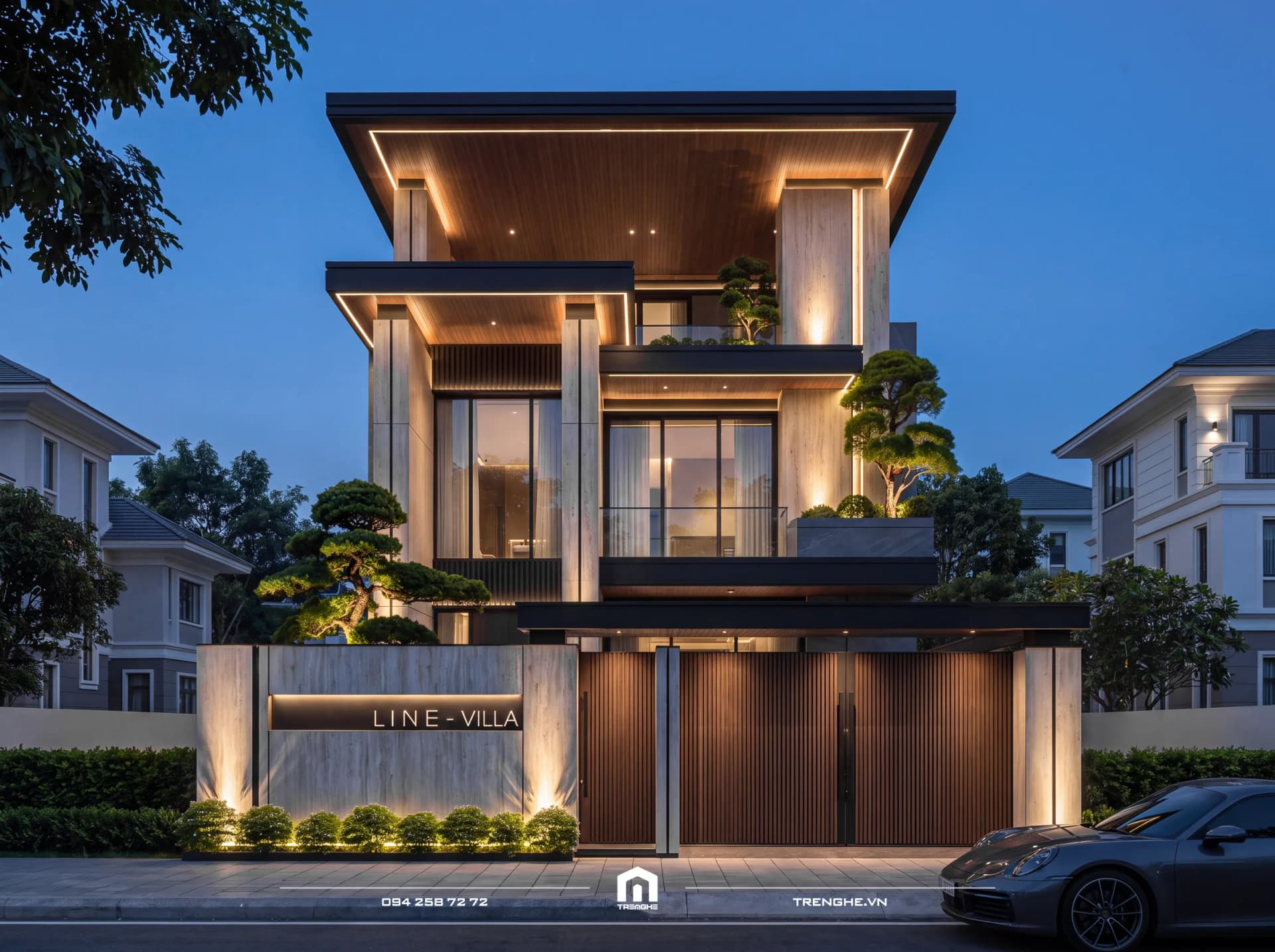 Mặt tiền biệt thự Line Villa lúc chạng vạng: trần gỗ hắt đèn LED dưới mái vươn rộng, cột ốp đá, tùng bonsai, bảng tên Line Villa và cổng lam gỗ
