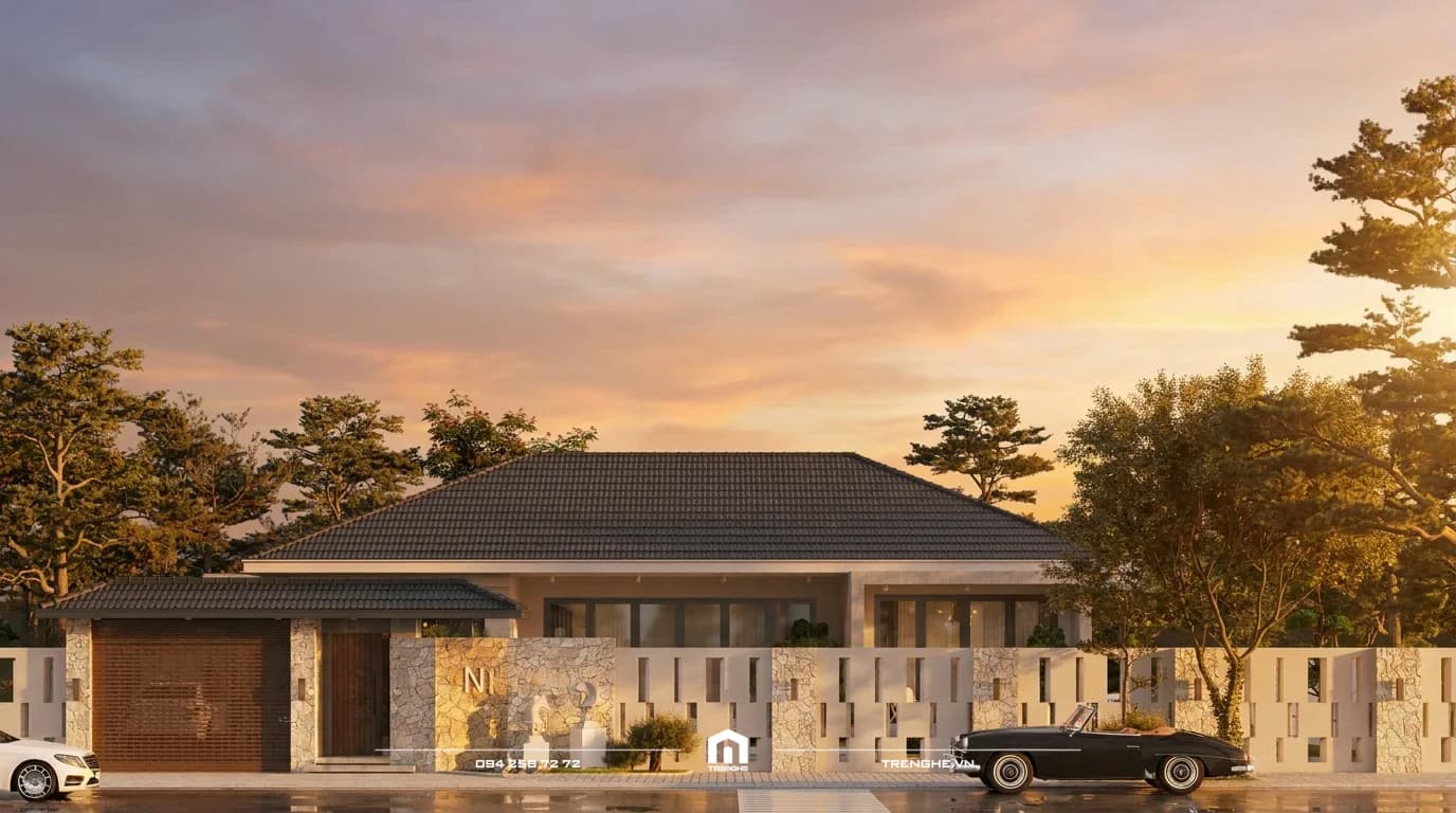 Mặt tiền nhà vườn N’ Villa một tầng lúc hoàng hôn với mái ngói Thái xám, tường cổng ốp đá và tường rào trắng