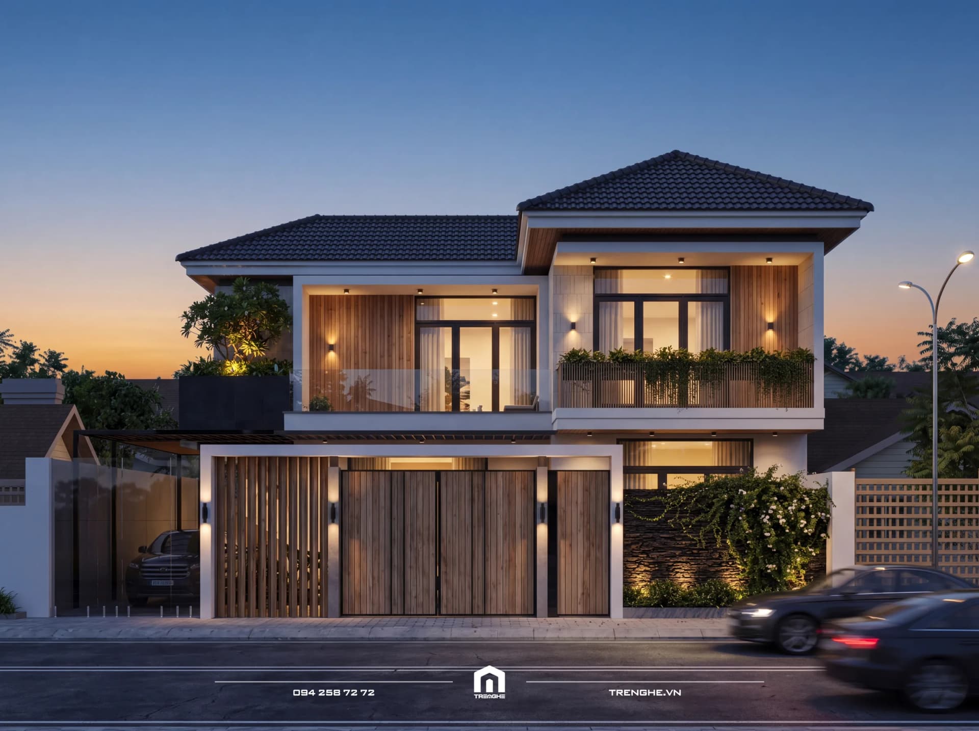 Biệt thự mái Nhật T’ Villa 2 tầng lúc hoàng hôn: mái ngói xám, ban công kính và bồn cây rủ xanh sáng đèn, cổng nan gỗ và tường đá chẻ phủ hoa leo