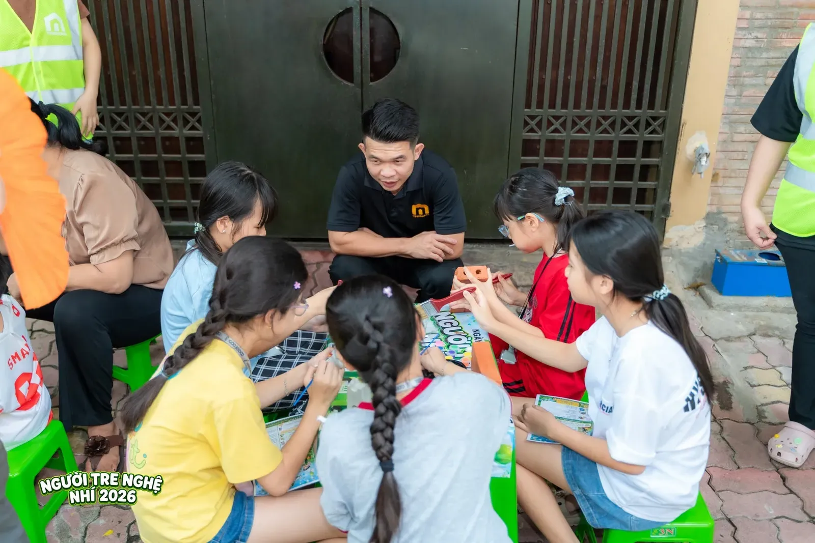 Thành viên ban tổ chức hào hứng hướng dẫn và cùng các bé sáng tạo nghệ thuật tại trạm Sắc Màu Của Gạch